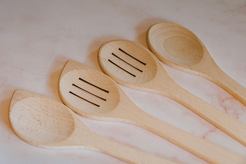 Close-up of wooden cooking spoons and spatulas arranged on a marble countertop. Ideal for kitchen decor.